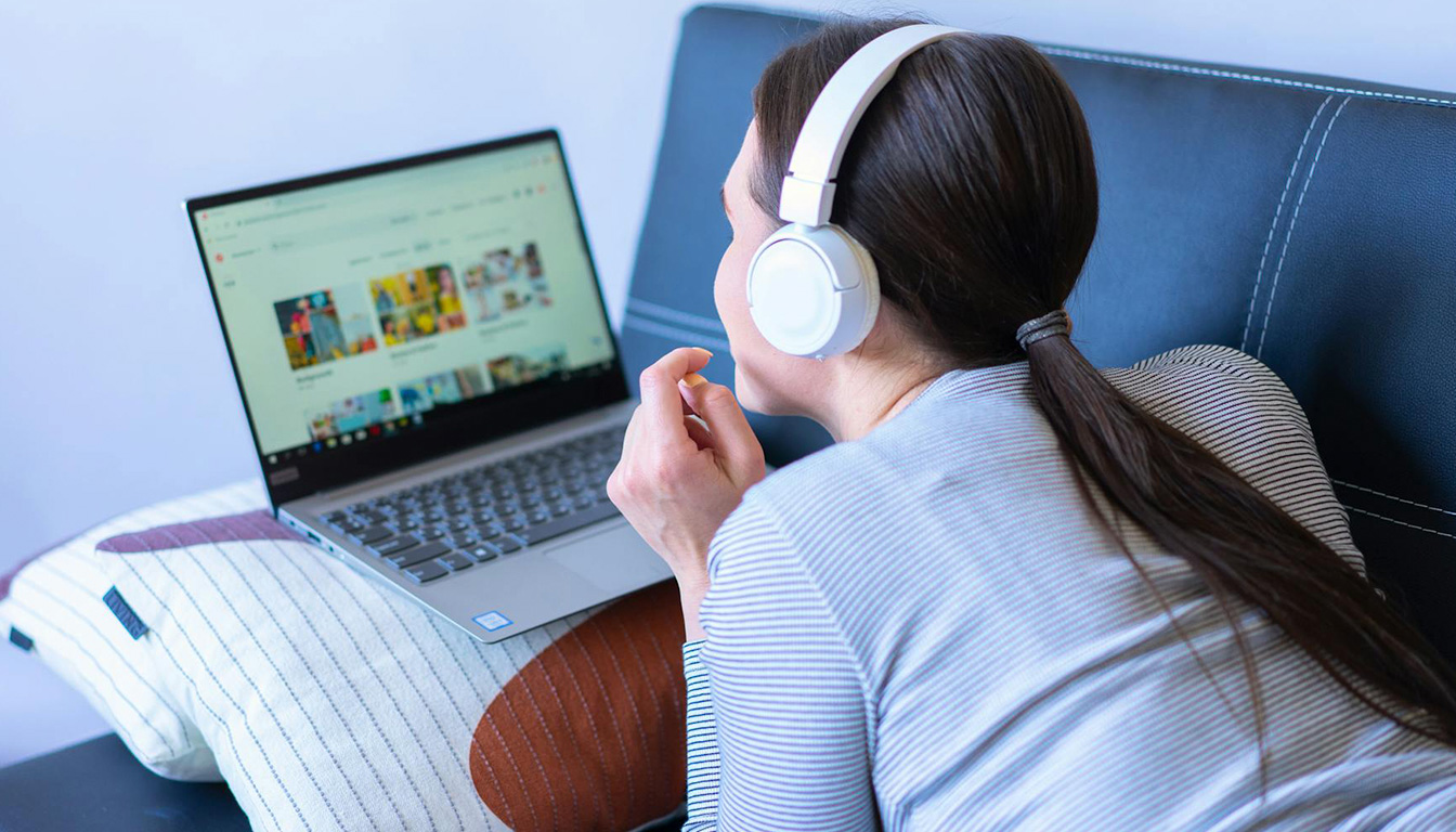 Comment convertir YouTube en MP3 — personne utilisant un ordinateur portable écouteurs musique